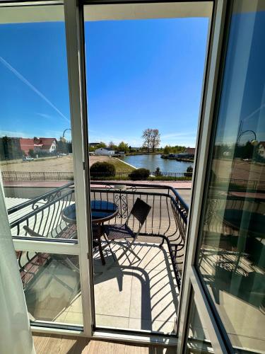 a balcony with a table and a view of a lake at Pod Papugami - Komfortowe pokoje z widokiem na rzekę in Łeba