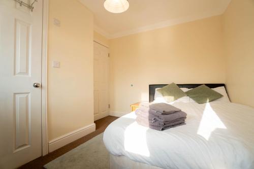 a bedroom with a bed with white sheets and pillows at Free Parking 6 Beds Fully Equipped Home Favourite by Contractors & Groups in Earley