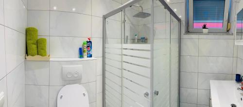 a white bathroom with a shower and a toilet at Holiday Apartment in Mörfelden-Walldorf in Mörfelden-Walldorf