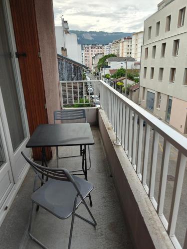 une table et une chaise sur un balcon dans l'établissement T1 bis rénové Grenoble et parking, à Grenoble