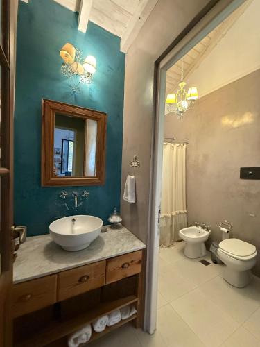 a bathroom with a sink and a toilet and a mirror at La Mora Home - Casa de Campo in Victoria