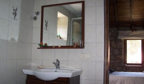 ein Bad mit einem Waschbecken und einem Spiegel in der Unterkunft Dikencik Cottages in Uzumlu