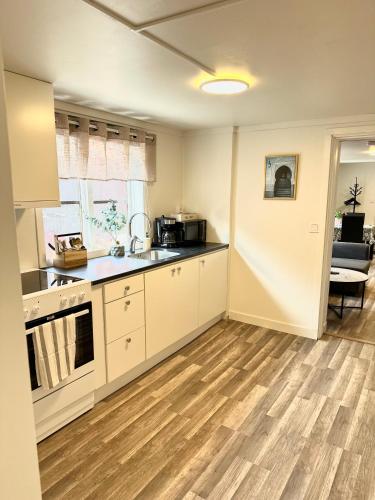 a kitchen with white cabinets and a wooden floor at Lägenhet på Stora Torget i Norrtälje in Norrtälje