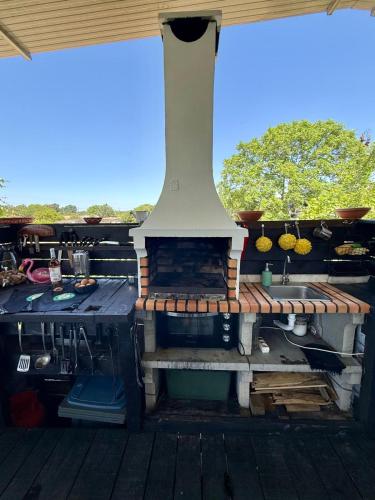 a outdoor fireplace with a sink on a deck at Monte do Bidé Private Farm Peace and Nature in Setúbal