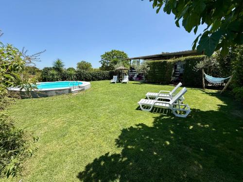 a yard with a lawn chair and a swimming pool at Monte do Bidé Private Farm Peace and Nature in Setúbal