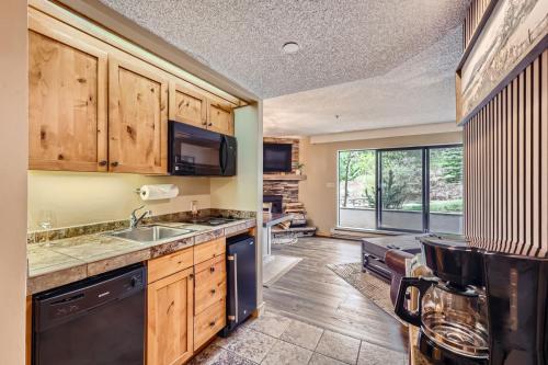a kitchen with wooden cabinets and a sink at Beaver Run, King Studio, Ground Floor, Dog Friendly in Breckenridge