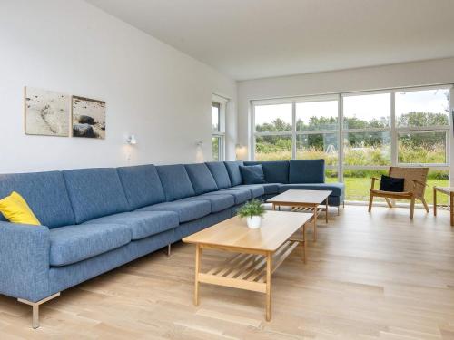 a living room with a blue couch and tables at Ho Holiday Center in Blåvand
