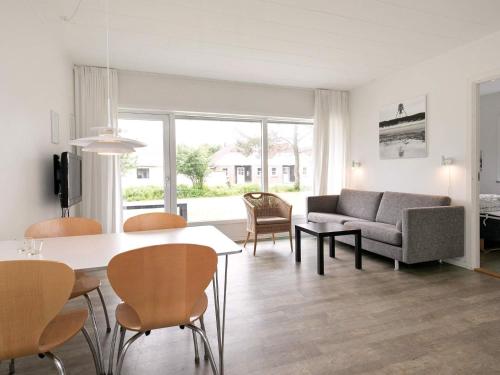 a living room with a couch and a table and chairs at Ho Holiday Center in Blåvand