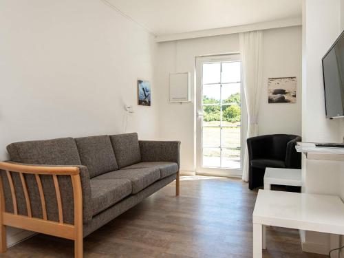a living room with a couch and a window at Ho Holiday Center in Blåvand