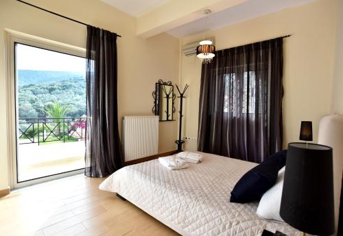a bedroom with a bed and a large window at Villa Merika in Kiveri