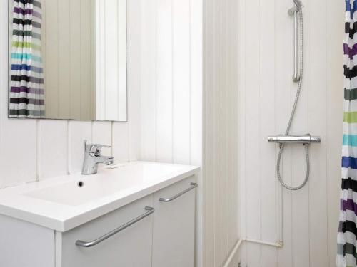 a white bathroom with a sink and a shower at 4 person holiday home on a holiday park in Blåvand in Blåvand
