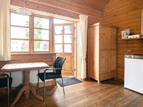 a kitchen with a table and chairs and a window at Ho Holiday Center in Blåvand