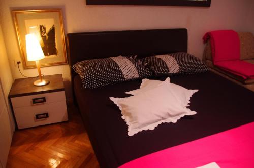 a bedroom with a bed with a pillow on it at Apartments Lux in Makarska