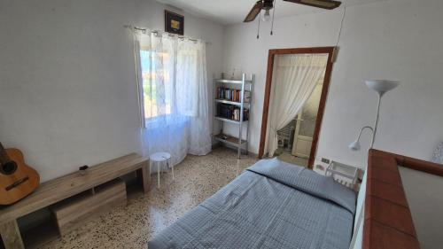 ein Schlafzimmer mit einem Bett und einer Gitarre darin in der Unterkunft Casa dolce Casa in Cologna