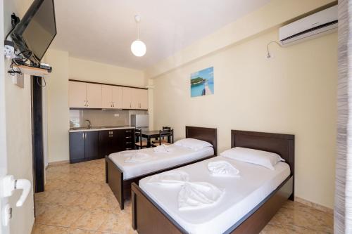 due letti in una stanza con cucina di Guesthouse A&F a Ksamil