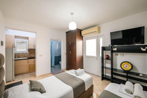 una camera d'albergo con due letti e una televisione di Guesthouse A&F a Ksamil