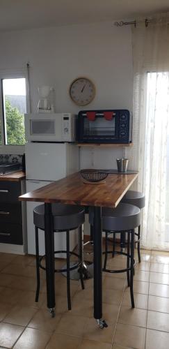 - une cuisine avec une table en bois, des chaises et un four micro-ondes dans l'établissement Hon Ti Bihan, à Henvic