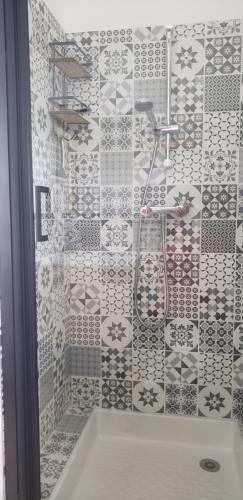 La salle de bains est pourvue d'une douche et d'un mur en carrelage. dans l'établissement Hon Ti Bihan, à Henvic