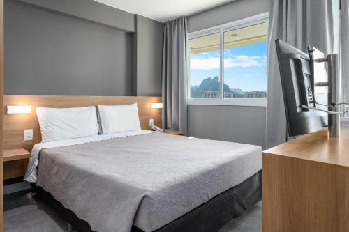 ein Hotelzimmer mit einem Bett und einem Fenster in der Unterkunft Verano Stay Barra Olímpica in Rio de Janeiro