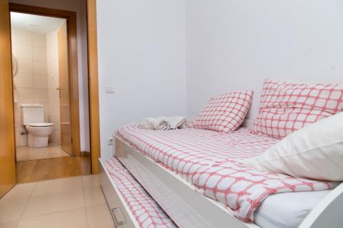 a bed with red and white pillows in a room at New & Sunny Apartment in Barcelona