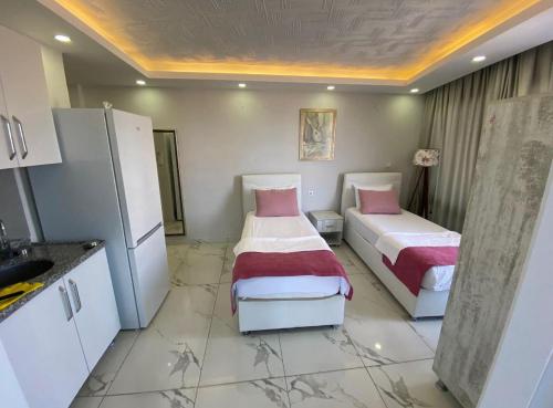 a kitchen with two beds in a room at Beyaz motel in Erdemli