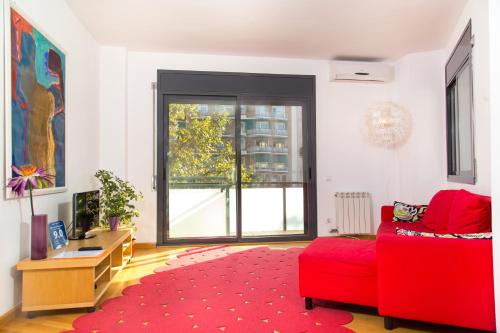 uma sala de estar com um sofá vermelho e um tapete vermelho em New & Sunny Apartment em Barcelona
