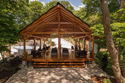 a wooden gazebo with chairs in the middle at Beach resort playa Leona in Gigantes