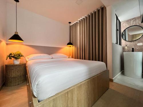 a bedroom with a large white bed and a bathroom at Salento Boutique Mini House, Private, Complete in Salento