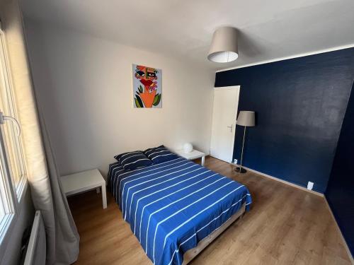 une chambre avec un lit avec une couette bleue dans l'établissement Bel appartement climatisé avec balcon en centre-ville, à Marseille