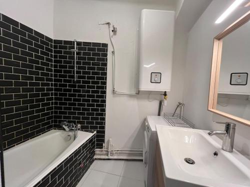 une salle de bain avec une baignoire et un lavabo et une baignoire dans l'établissement Bel appartement climatisé avec balcon en centre-ville, à Marseille