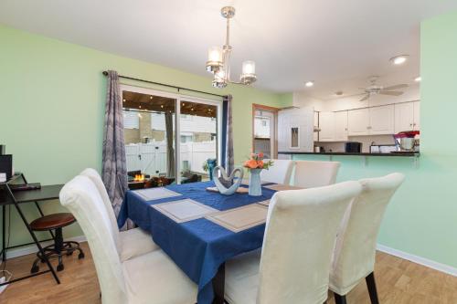 a dining room with a blue table and white chairs at The Ultimate Escape. Unpack, Relax, Enjoy!Sleeps14 in Elmhurst