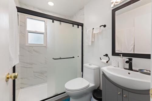 a white bathroom with a toilet and a sink at The Ultimate Escape. Unpack, Relax, Enjoy!Sleeps14 in Elmhurst