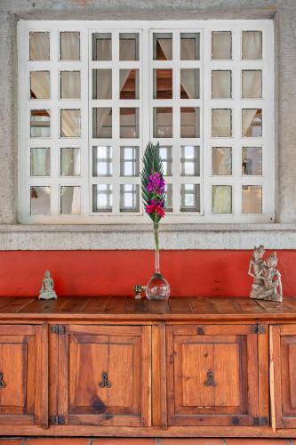 a vase with flowers on top of a wooden cabinet at Private 5-Bedroom Compound with Pool Tepoztlán Retreat in Tepoztlán