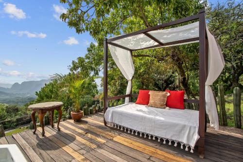 a bed on a wooden deck with a canopy at Private 5-Bedroom Compound with Pool Tepoztlán Retreat in Tepoztlán