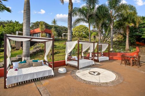 a patio with three beds and a table and chairs at Private 5-Bedroom Compound with Pool Tepoztlán Retreat in Tepoztlán