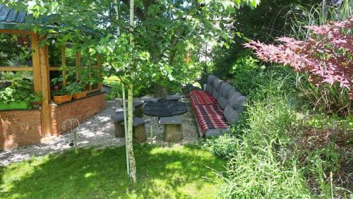 a garden with a bench and a picnic table and a tree at Sarajevo Chalet in Hadžići