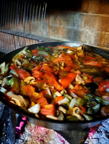 a pan filled with vegetables cooking in an oven at Sarajevo Chalet in Hadžići