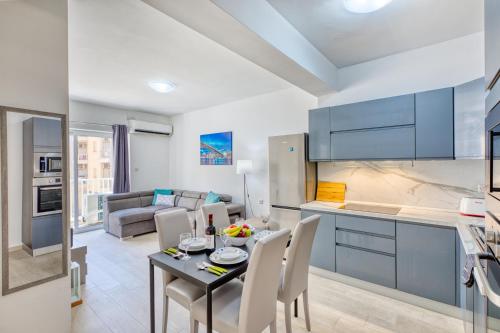a kitchen and living room with a table and chairs at The Apateu in St Paul's Bay