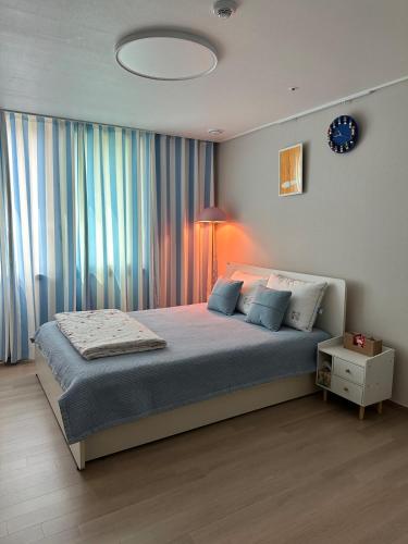 a bedroom with a bed with a lamp and a window at 킨텍스 홍대 서울역 김포공항 고양종합운동장- Foreigner Only in Goyang