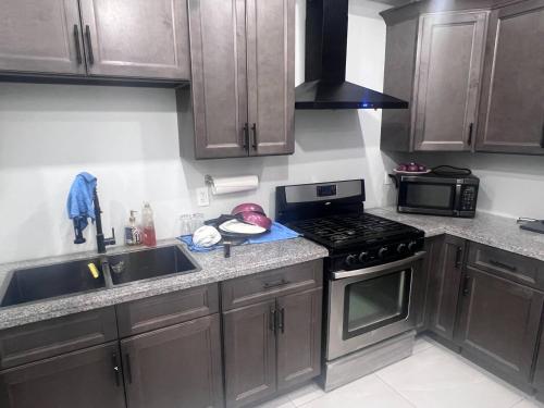Una cocina con gabinetes de madera y un horno de estufa. en B12 Private Room In Cambridge, en Cambridge