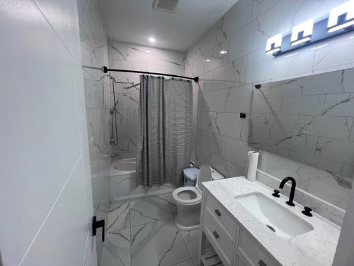 Un baño blanco con lavabo e inodoro. en B12 Private Room In Cambridge, en Cambridge