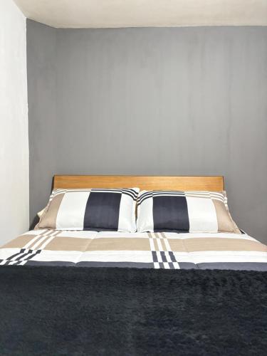 a bed with black and white pillows on it at Room Airport in Bogotá