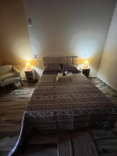 a bedroom with a large bed and two chairs at Chalés do vale Extrema vermelho in Extrema