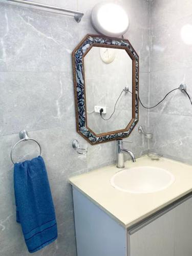 a bathroom with a sink and a mirror on the wall at Premium Haim apt in Haifa