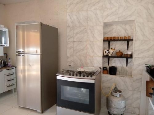 eine Küche mit Herd und Kühlschrank in der Unterkunft Granja ao lado da festa Soul João in Lagoa Sêca
