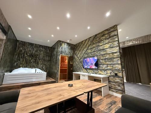 a room with a wooden table and a tv at Black Mont İnn Hotel in Baku