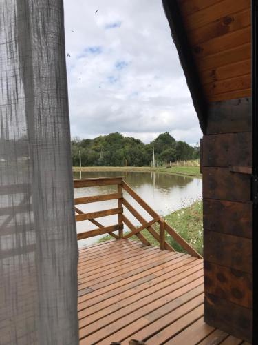 a wooden deck with a view of a lake at Rancho dos lagos in Campo Alegre