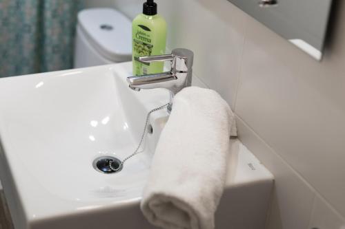 a bathroom sink with a towel hanging from a faucet at Autèntic Arc de Triomf Apartment in Barcelona