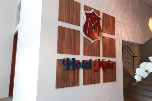 a door with a wood sign on it at Hotel Maia in Betim