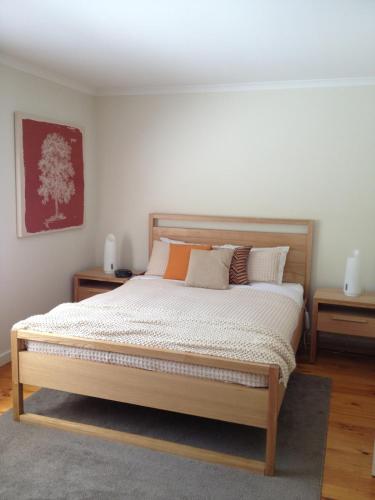 a bedroom with a bed with two night stands and two tables at Tikkandi in Merrijig